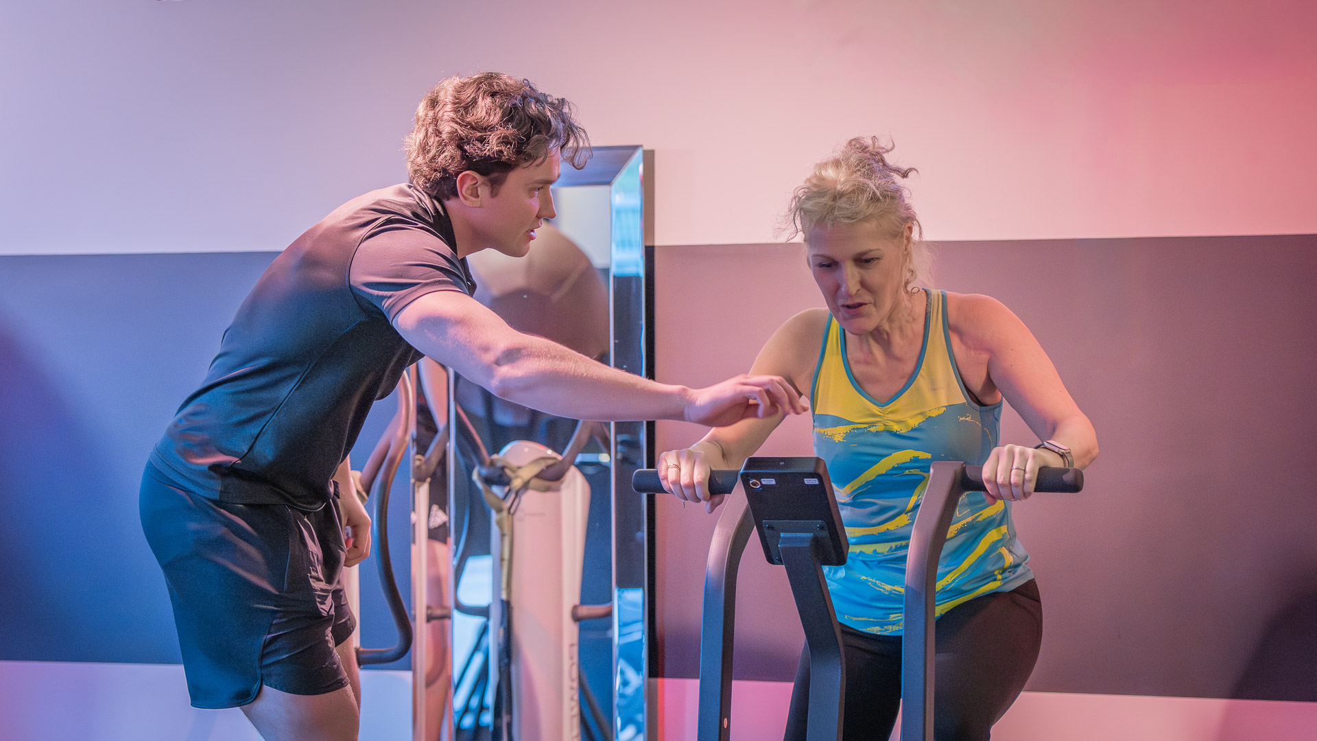 Coach sportif à Lille corrigeant la posture d'une adhérente en cardio-training chez PWS